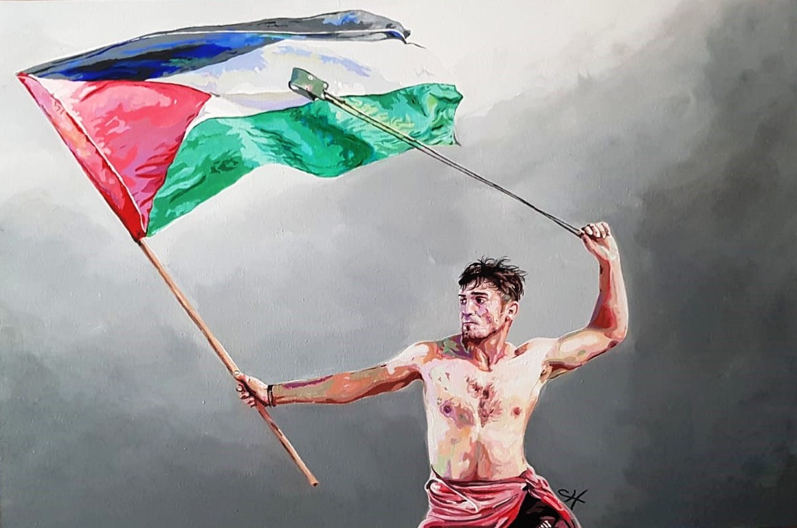 A bare chested man waving a Palestinian flag